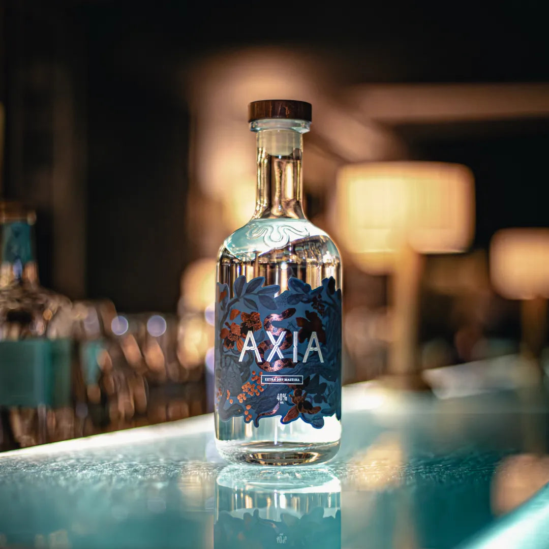 Bottle of Axia Mastiha Spirit on a light blue bar counter