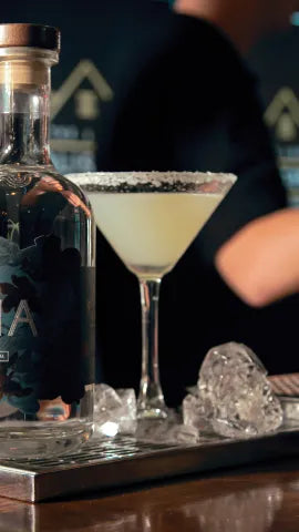 Axia Margarita Cocktail on a bar with an Axia bottle next to it